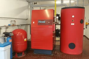Caldaia e bollitore rossi in una centrale termica condominiale
